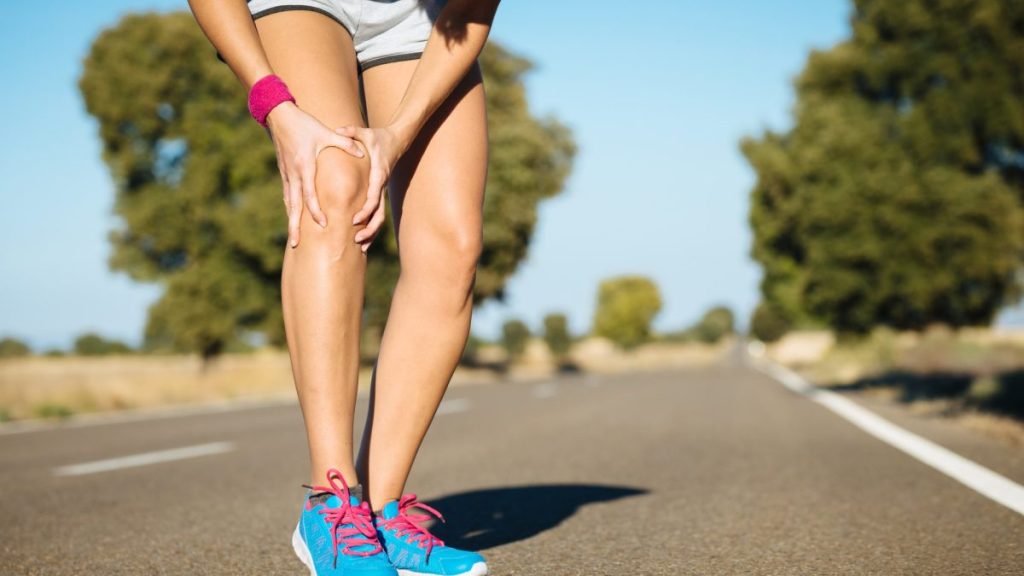 Runner holding shin in pain during training in Brisbane